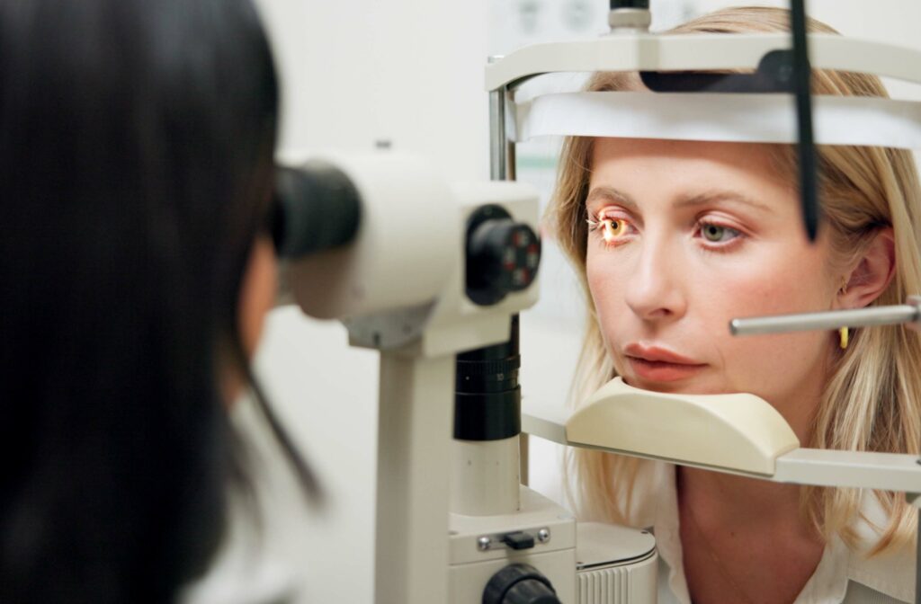 An eye doctor examines the internal structure of her patient's eye with a slit lamp during a glaucoma screening.