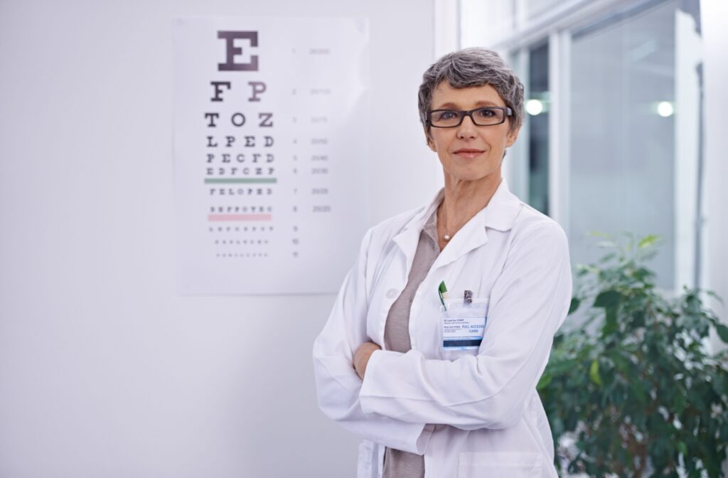 A portrait of a mature optometrist smiling with her arms crossed.