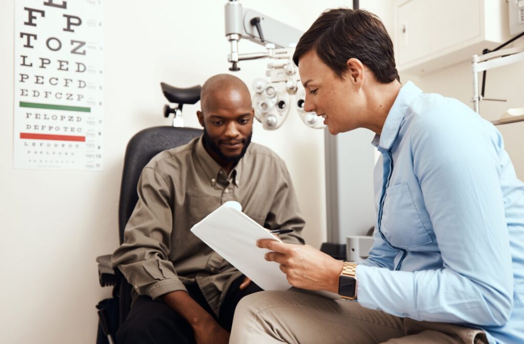 A man sitting with his optometrist to understand the diagnosis of his eye exam.