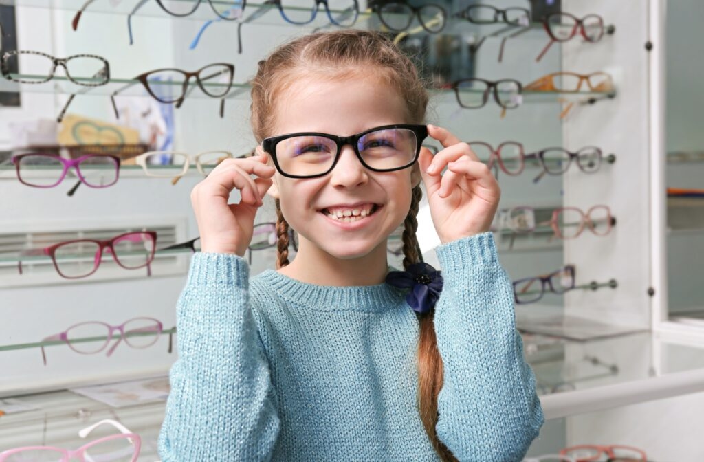 Young girl trying on new glasses in an optometry office.