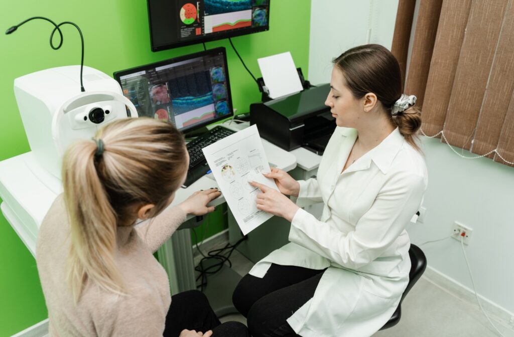 An optometrist evaluates the results patient's retinal scans.